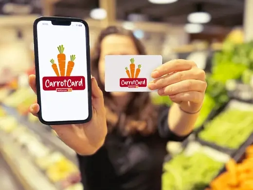 Frau hält Handy und CarrotCard in die Kamera