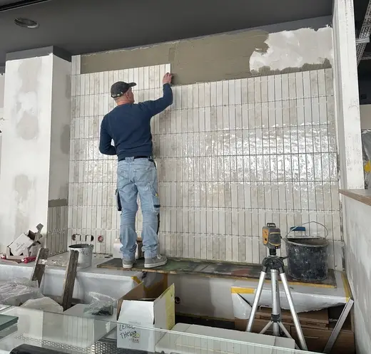 Mann der die Wand fliest