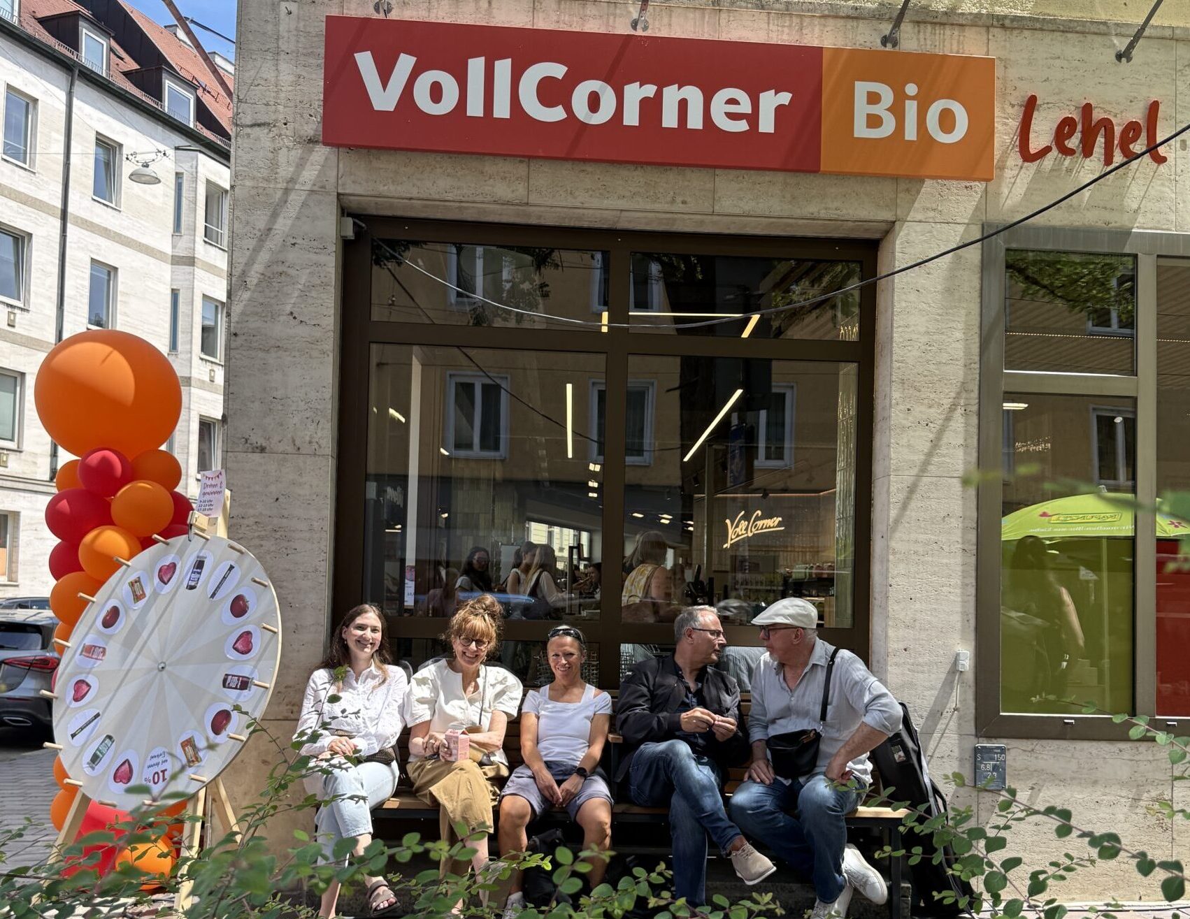 Fünf Menschen sitzen vor der neuen VollCorner Lehel